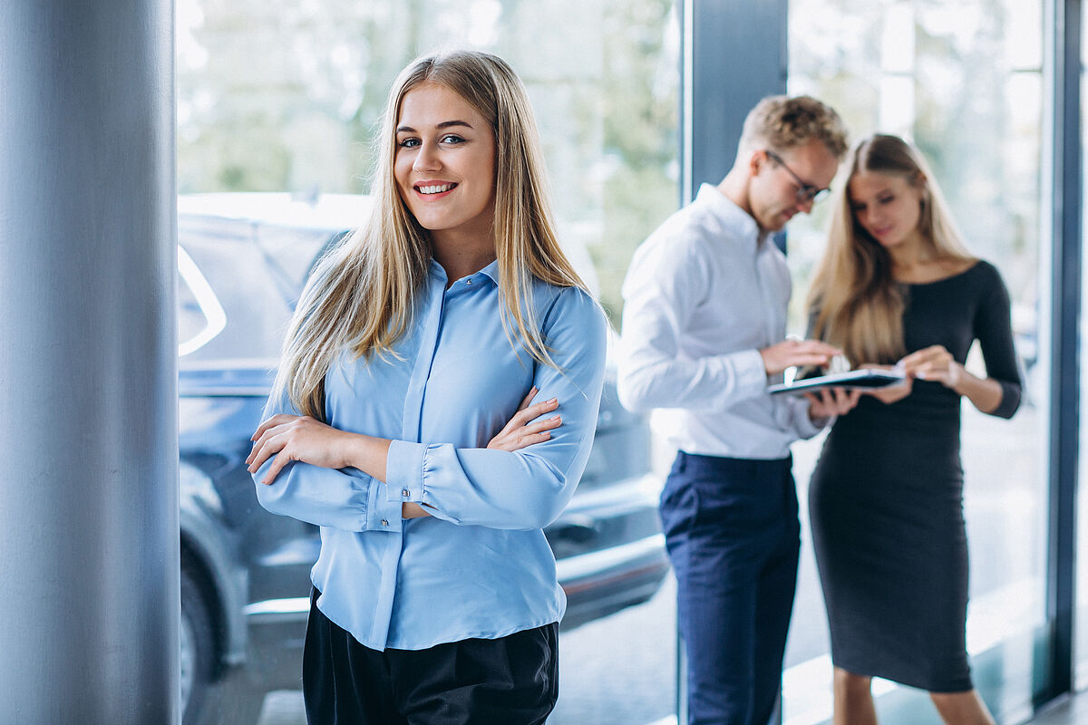 Ausbildung Automobilkaufmann/-frau Three collegues working at a car showroom